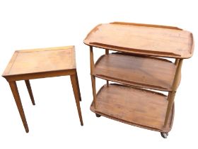 An Ercol elm three-tier trolley with rounded rectangular shelves on spindle supports with