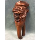 A C19th Swiss carved walnut nutcracker in the form of a comical old man wearing a tricorn hat and