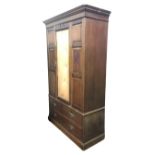 A late Victorian mahogany wardrobe, the dentil cornice above a central door flanked by carved