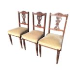 A set of three Edwardian mahogany chairs with carved arched backs and pierced vase foliate carved