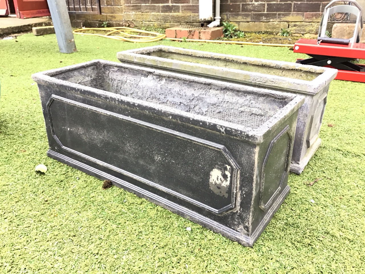A pair of rectangular faux lead garden troughs with moulded plinths and rims, having panelled sides. - Image 2 of 3