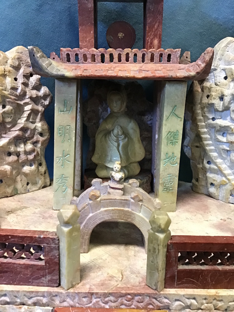 An Edwardian carved soapstone temple, with kneeling figure in covered building framed by stylised - Image 2 of 3