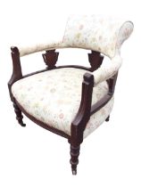 An Edwardian mahogany captains armchair with outscrolled backrest and padded arms raised on carved