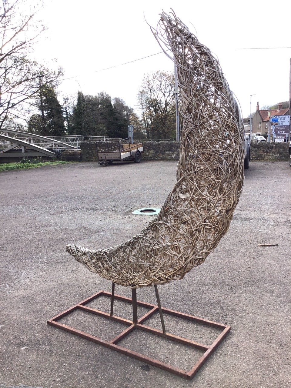 A woven willow crescent shaped sculpture on metal frame with rectangular stand. (80in) - Image 2 of 3