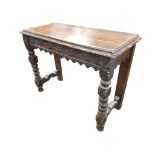A Victorian oak jacobean style console table with rectangular leaf carved top above a waved ribbon