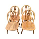 A set of four elm Ercol chairs with Prince of Wales pierced splats and hooped backs on spindles