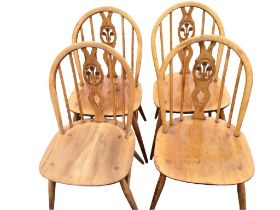 A set of four elm Ercol chairs with Prince of Wales pierced splats and hooped backs on spindles