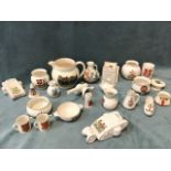 A collection of crested ceramics including two WWI tanks, a cannon, a military cap, a watchtower,