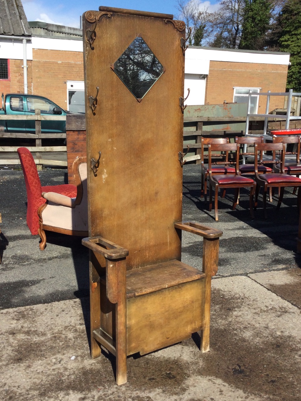 A 1930s oak hallstand with applied scrolled carving and six pegs to back, above a seat with hinged - Image 3 of 3