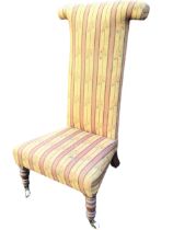 A Victorian prie-dieu chair with high woolwork upholstered back and flared seat raised on turned