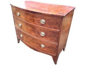 A nineteenth century mahogany bowfronted chest of three long cockbeaded drawers mounted with oval
