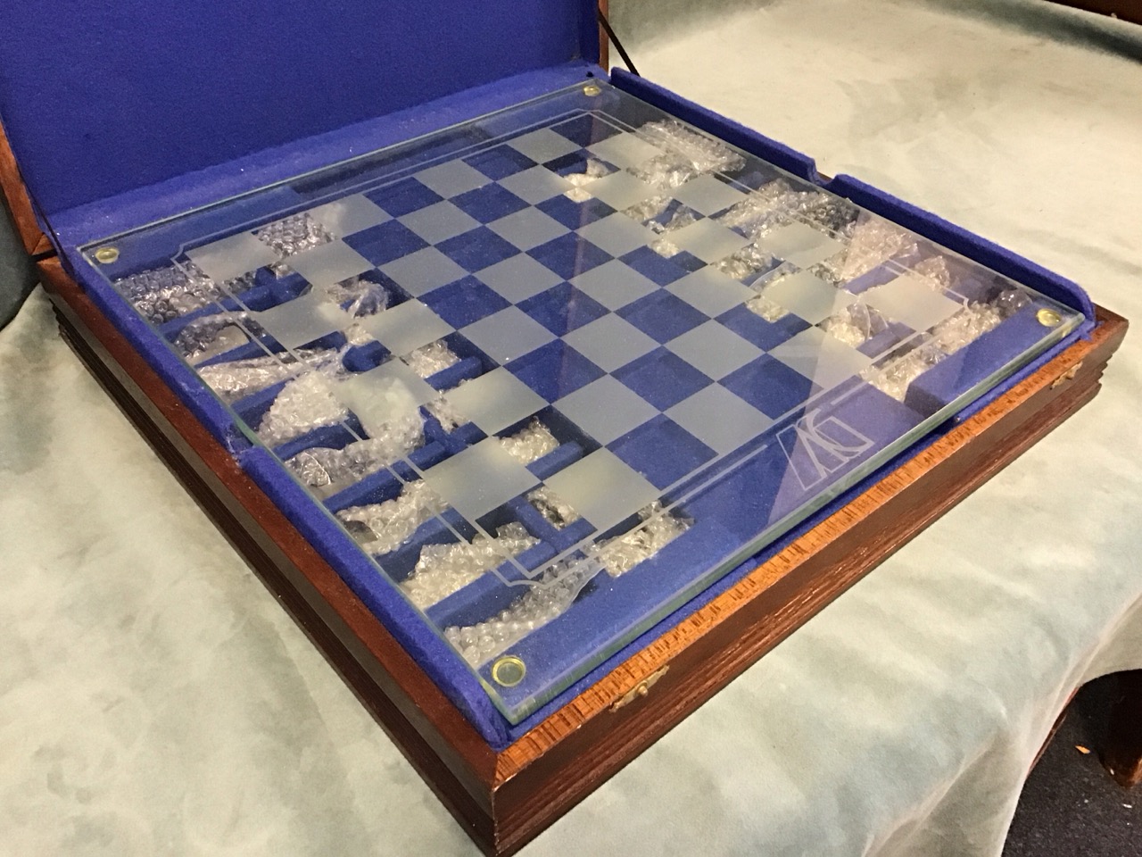 A cased contemporary glass chess set with frosted & clear glass pieces, on thick plate glass