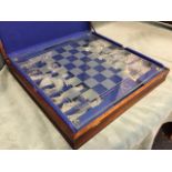 A cased contemporary glass chess set with frosted & clear glass pieces, on thick plate glass