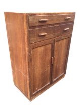 A C20th oak utility cabinet with moulded top above two long drawers and panelled cupboard doors,