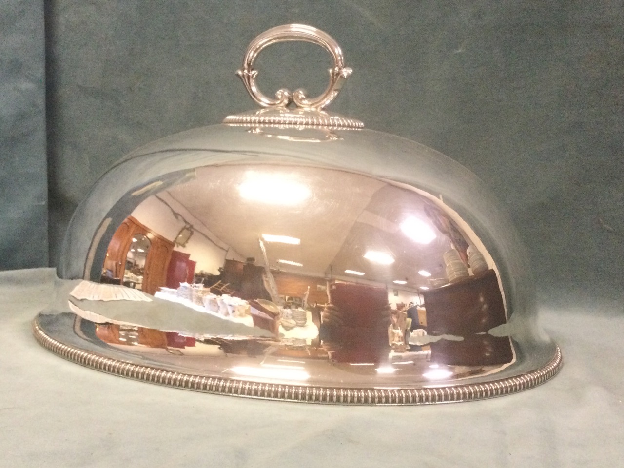 A late Victorian oval domed silver plated food cover with scrolled handle and beaded decoration. (