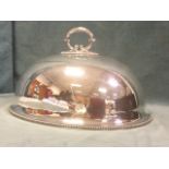 A late Victorian oval domed silver plated food cover with scrolled handle and beaded decoration. (