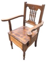 An Edwardian mahogany armchair with carved crestrail and turned spindle back above a rectangular