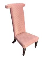 A Victorian prie-dieu chair, the high upholstered back above a flared seat, raised on turned