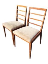 A pair of 60s mahogany chairs with rectangular ladderbacks above flared rectangular upholstered