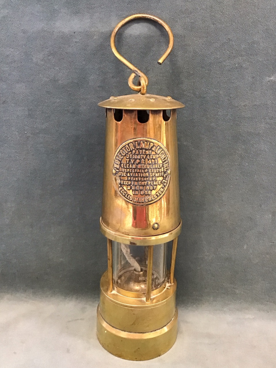 A brass miners lamp by the Protector Lamp & Lighting Co - Eccles, serial no. 54546, with hook to