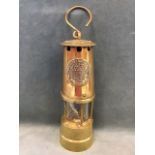 A brass miners lamp by the Protector Lamp & Lighting Co - Eccles, serial no. 54546, with hook to