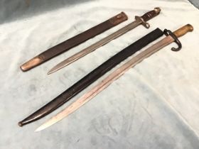 A French chassepot bayonet with brass hilt and steel scabbard, the blade engraved with the St