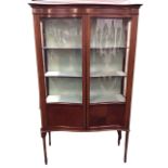 An Edwardian mahogany serpentine fronted display cabinet with moulded cornice and boxwood & ebony