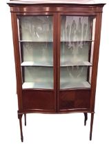 An Edwardian mahogany serpentine fronted display cabinet with moulded cornice and boxwood & ebony