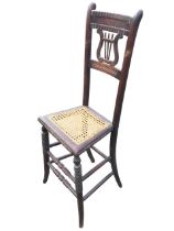 A regency tall backed childs correction chair with dentil carved crestrail and pierced lyre splat