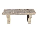 A rectangular composition stone garden bench with moulded slab seat on panelled waisted supports. (