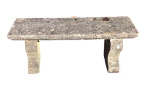 A rectangular composition stone garden bench with moulded slab seat on panelled waisted supports. (