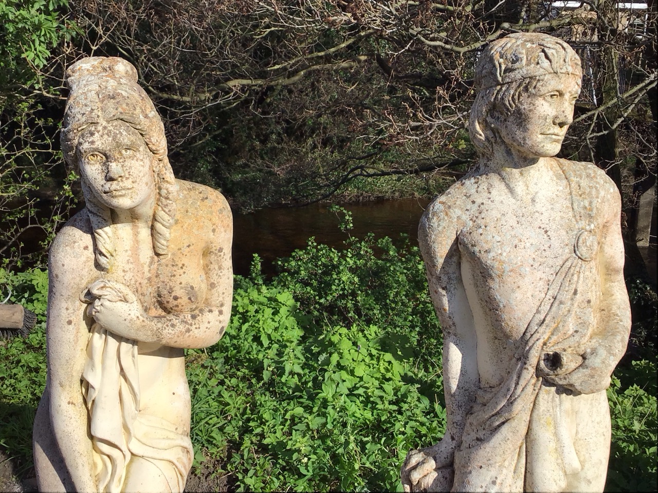 A pair of classical composition stone garden statues with a draped couple standing by logs on square - Image 3 of 3