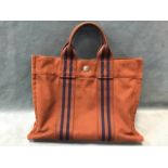 A brown Hermès Fool Toe tote bag with pop fastenings and internal zipped compartment.