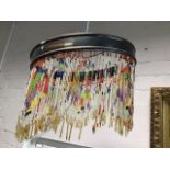 A C20th hanging light shade, the metal frame with coloured beaded strands.