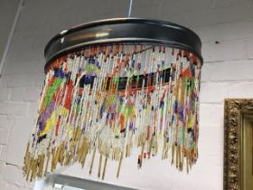 A C20th hanging light shade, the metal frame with coloured beaded strands.