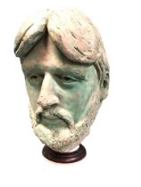 A life sized verdigris patinated composition portrait head of John Entwistle, on a turned ebonised