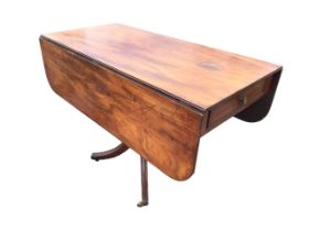 A regency mahogany dining table with rounded rectangular top and two leaves supported on brackets