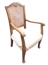 A 20s walnut armchair with waved crestrail and caned back above an upholstered rectangular seat