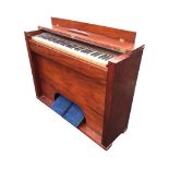 A mahogany cased harmonium with five octave keyboard in plain cabinet with twin working pedals. (