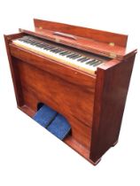 A mahogany cased harmonium with five octave keyboard in plain cabinet with twin working pedals. (