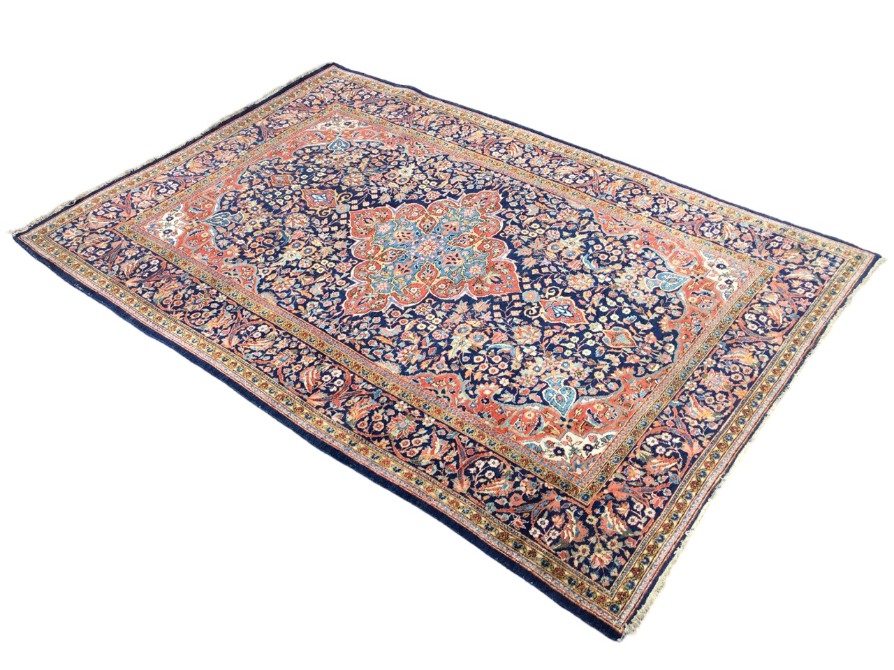A Keshan wool rug with a quatrefoil floral medallion in a dense floral field on a blue ground,
