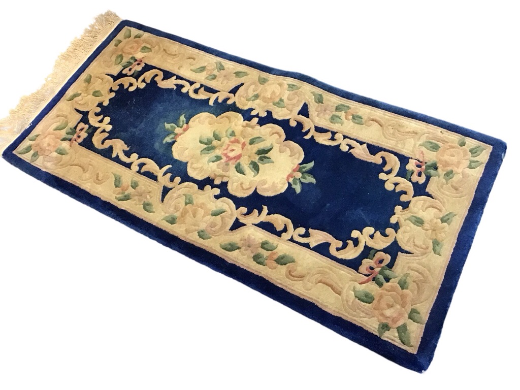 A Chinese wool aubusson style rug with floral medallion on a blue field within scrolling foliate and
