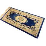 A Chinese wool aubusson style rug with floral medallion on a blue field within scrolling foliate and