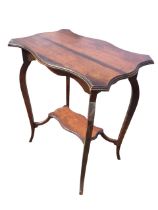An Edwardian mahogany occasional table with serpentine moulded top above a shaped apron, raised on
