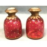A pair of Victorian cranberry glass Palais Royal scent bottles of domed form having giltmetal