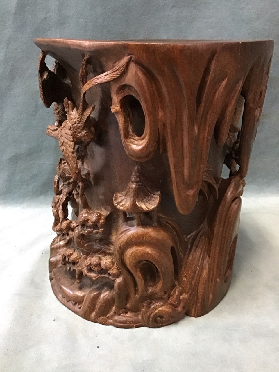 A large Chinese rosewood brush pot carved in high relief with a rocky landscape, pavilion, waterfall