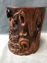 A large Chinese rosewood brush pot carved in high relief with a rocky landscape, pavilion, waterfall