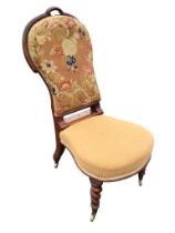 A Victorian mahogany chair with floral woolwork upholstered spoon back above a rounded sprung