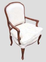 An upholstered armchair with rounded back in moulded frame above a seat with loose cushion, the arms