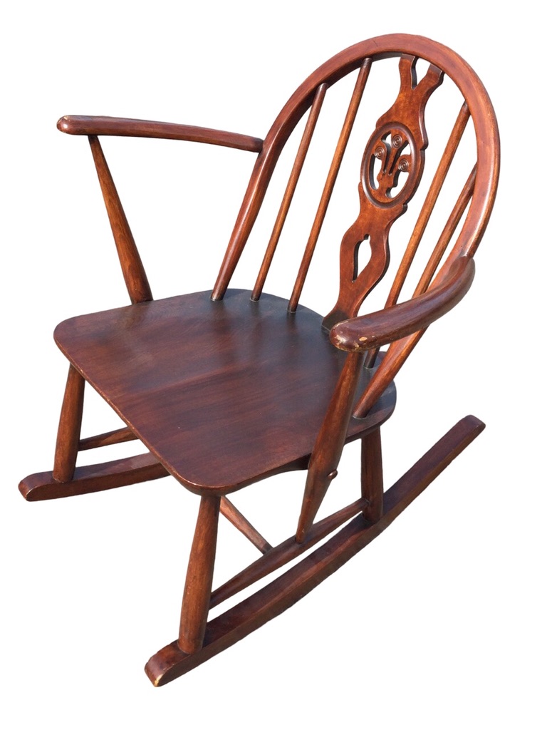 An Ercol elm & beech rocking chair with arched spindled back and Prince of Wales feather pierced